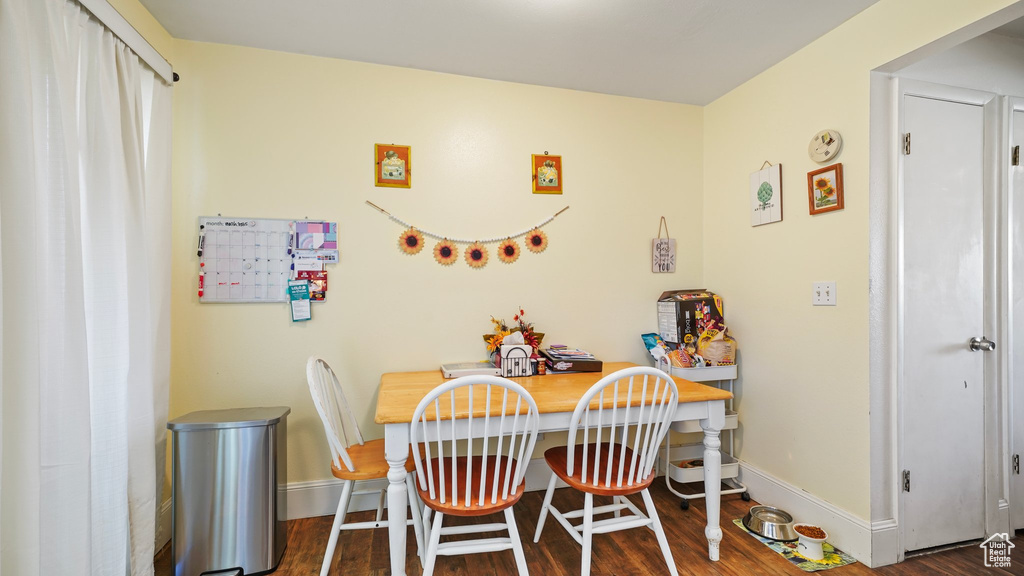Dining room with baseboards and dark wood-style flooring