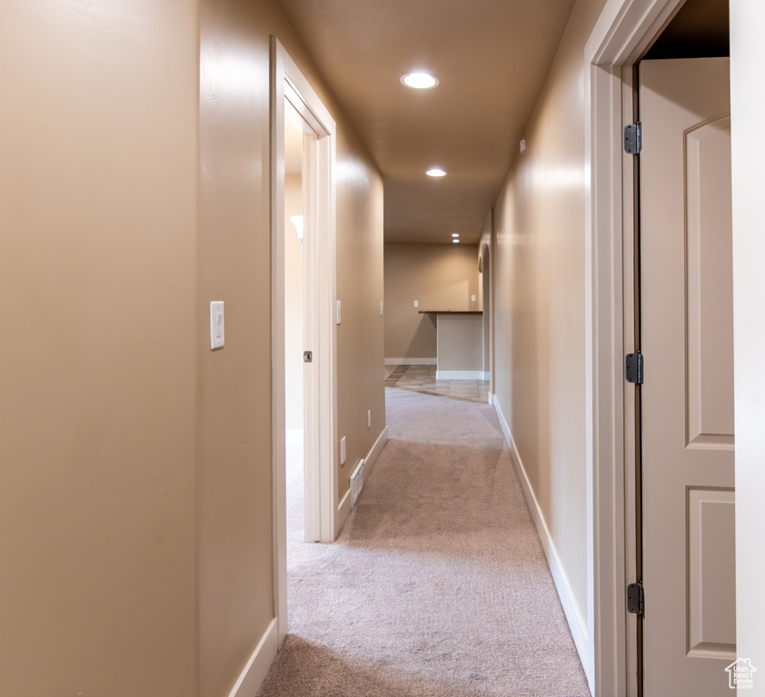 Corridor featuring light carpet, baseboards, and recessed lighting