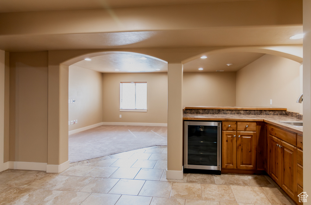 Bar with wine cooler, recessed lighting, light carpet, a dry bar, and a sink