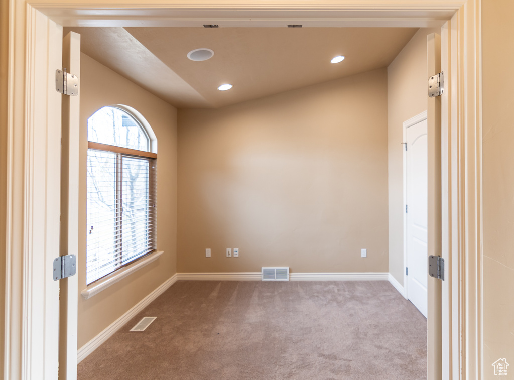Carpeted empty room with a wealth of natural light, baseboards, and visible vents