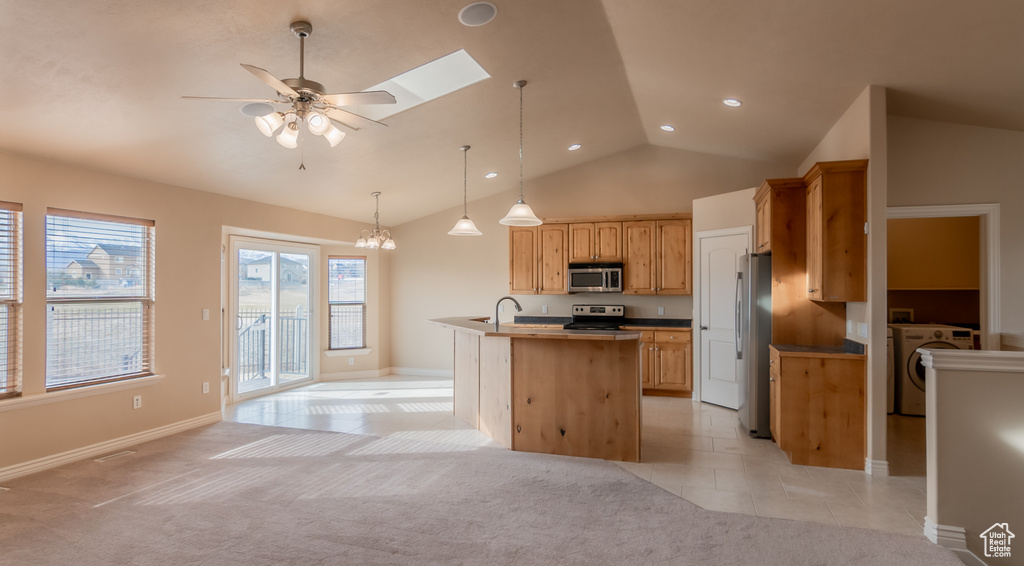Kitchen with light tile patterned flooring, light colored carpet, washer / dryer, and appliances with stainless steel finishes