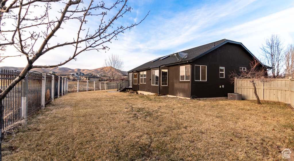 View of yard with cooling unit, a fenced backyard, and a mountain view