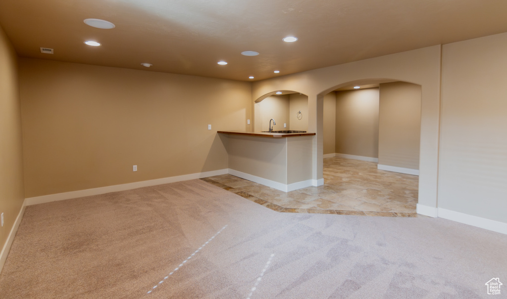 Interior space featuring light colored carpet, recessed lighting, baseboards, arched walkways, and visible vents