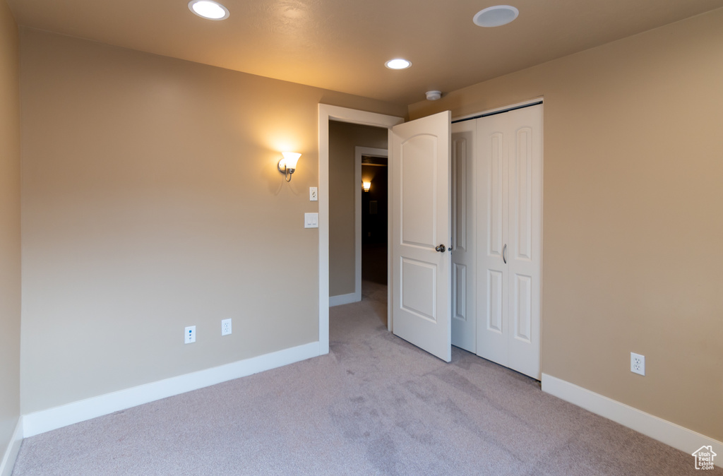 Unfurnished bedroom with a closet, carpet, baseboards, and recessed lighting