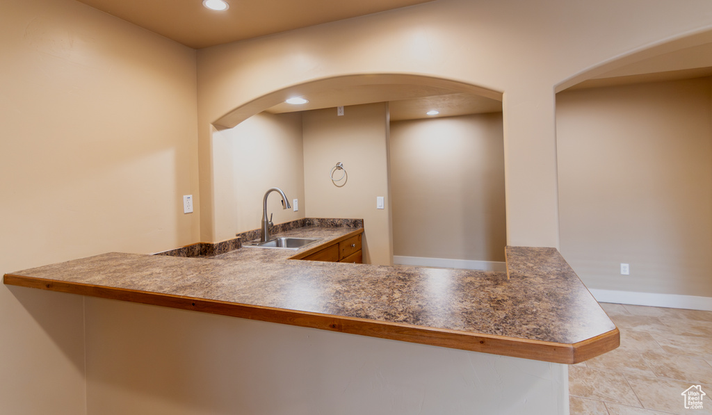 Kitchen with a sink, arched walkways, a peninsula, and recessed lighting