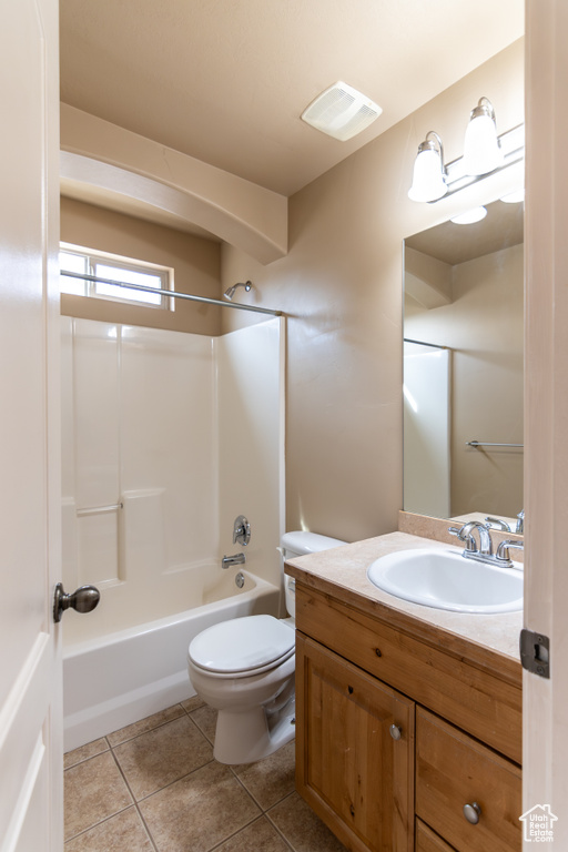 Full bath with visible vents, toilet, tile patterned floors, vanity, and shower / tub combination