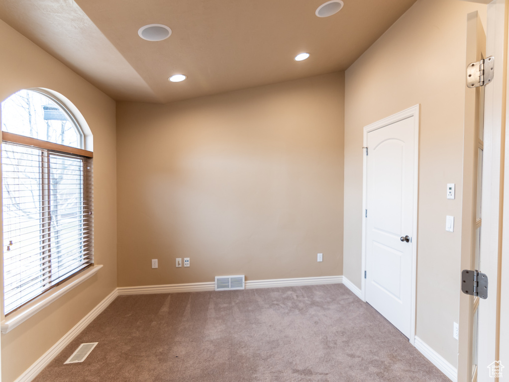 Carpeted empty room featuring a wealth of natural light, visible vents, recessed lighting, and baseboards