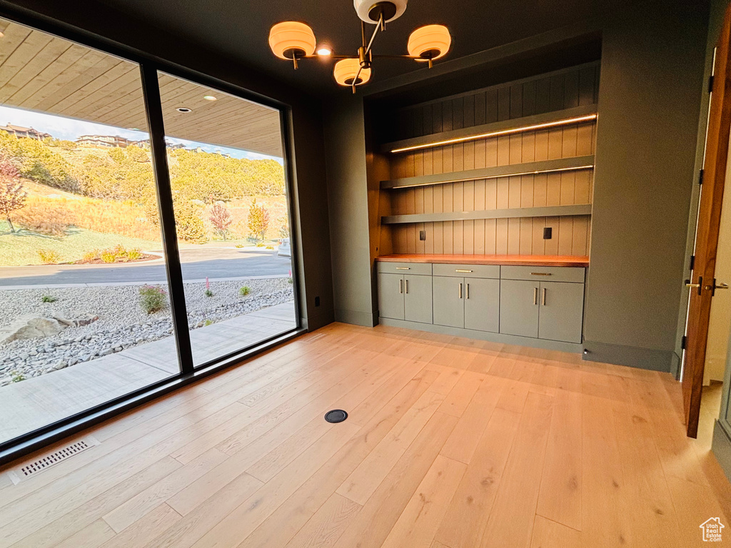 Unfurnished dining area featuring light wood-style floors and built in shelves