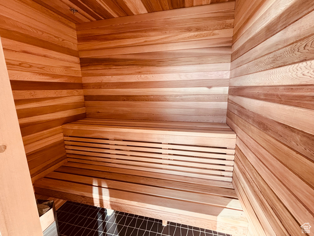 Relaxing sauna / steam room with tile patterned floors and wooden walls