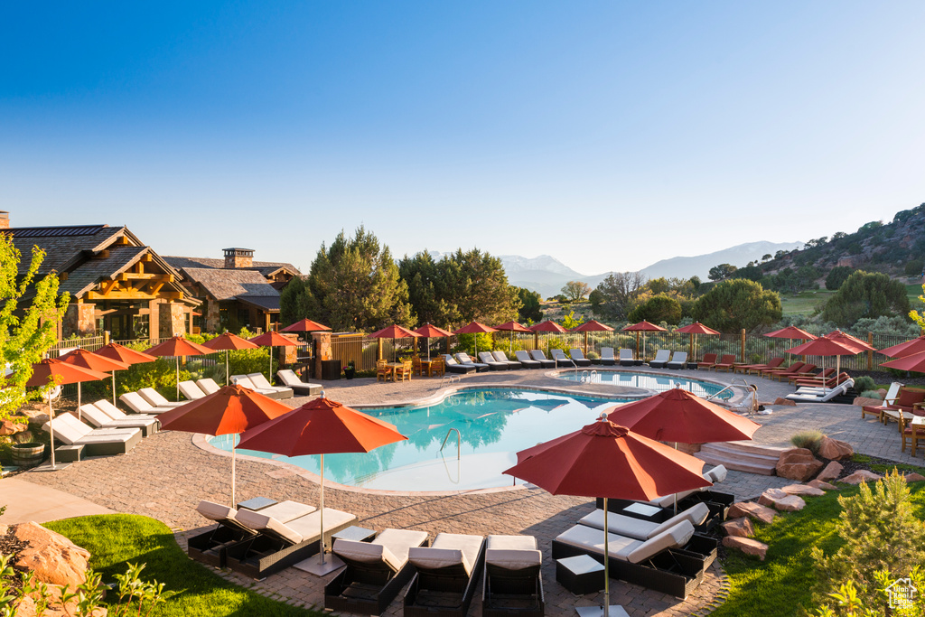 Pool with fence, a mountain view, and a patio