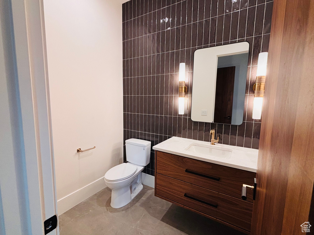 Half bathroom with tile walls and vanity