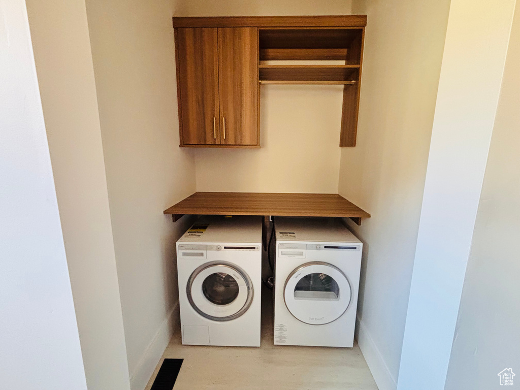 Laundry room featuring washing machine and dryer and light wood-style flooring