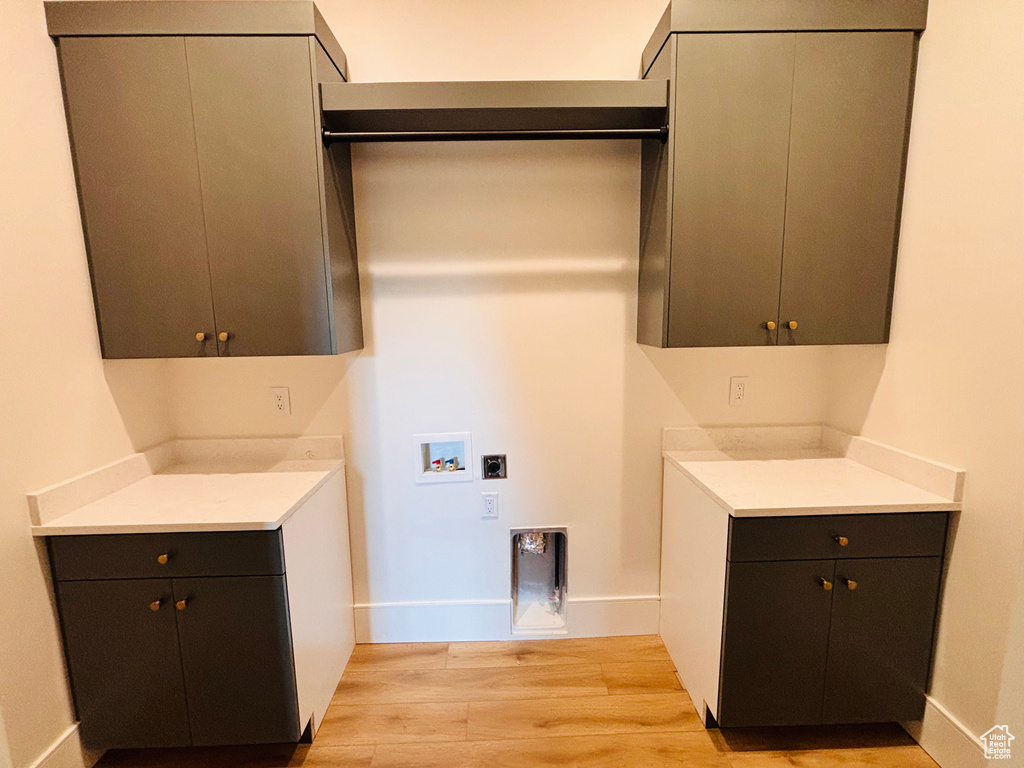 Laundry area featuring cabinet space, light wood-style flooring, and washer hookup