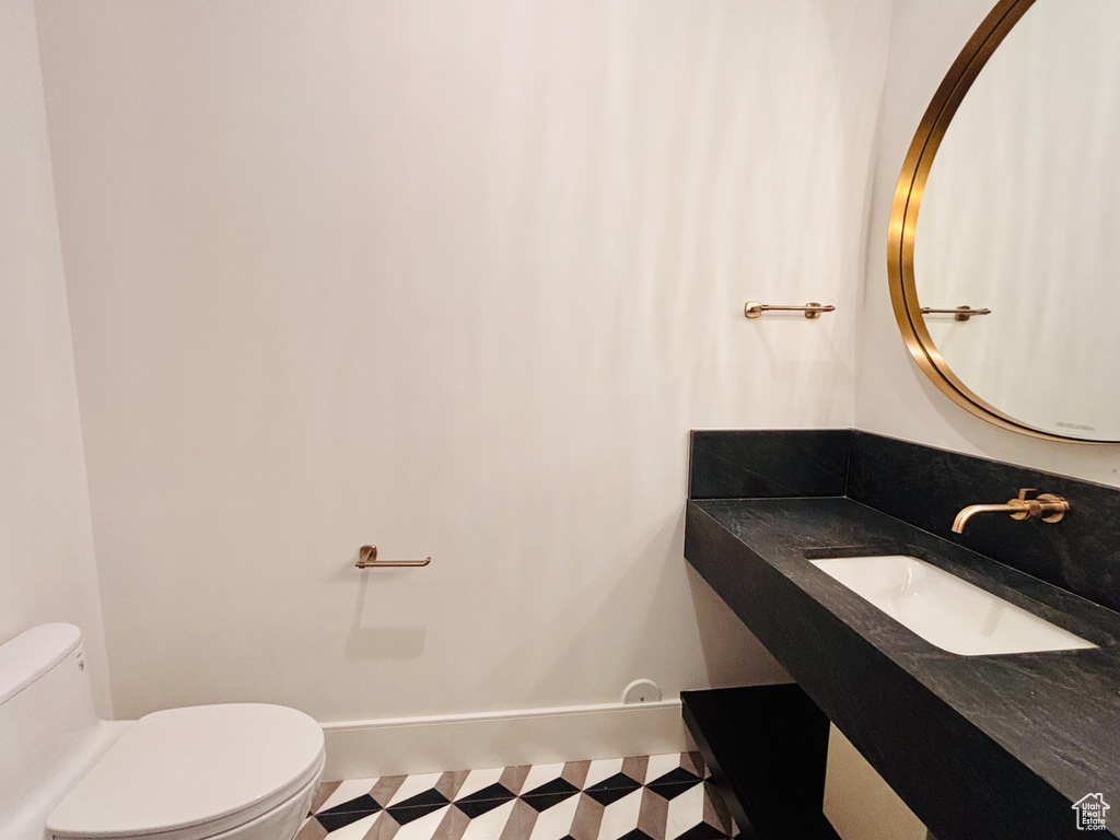 Half bath with vanity and tile patterned floors