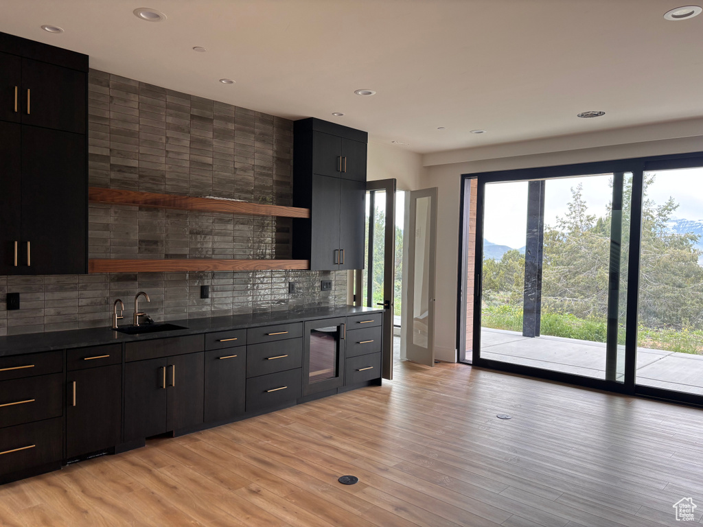Kitchen with tasteful backsplash, open shelves, dark countertops, a sink, and recessed lighting