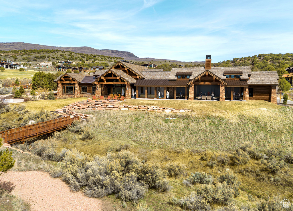 View of front of house featuring a mountain view, metal roof, a chimney, and a standing seam roof