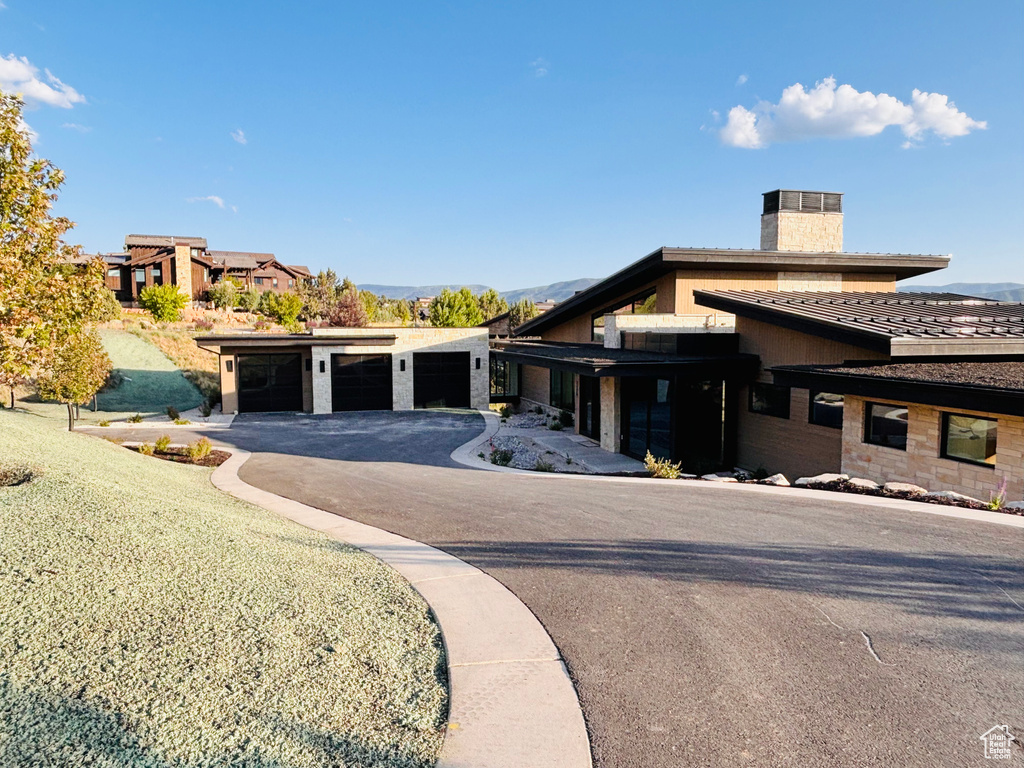 View of front of home featuring a chimney and stucco siding