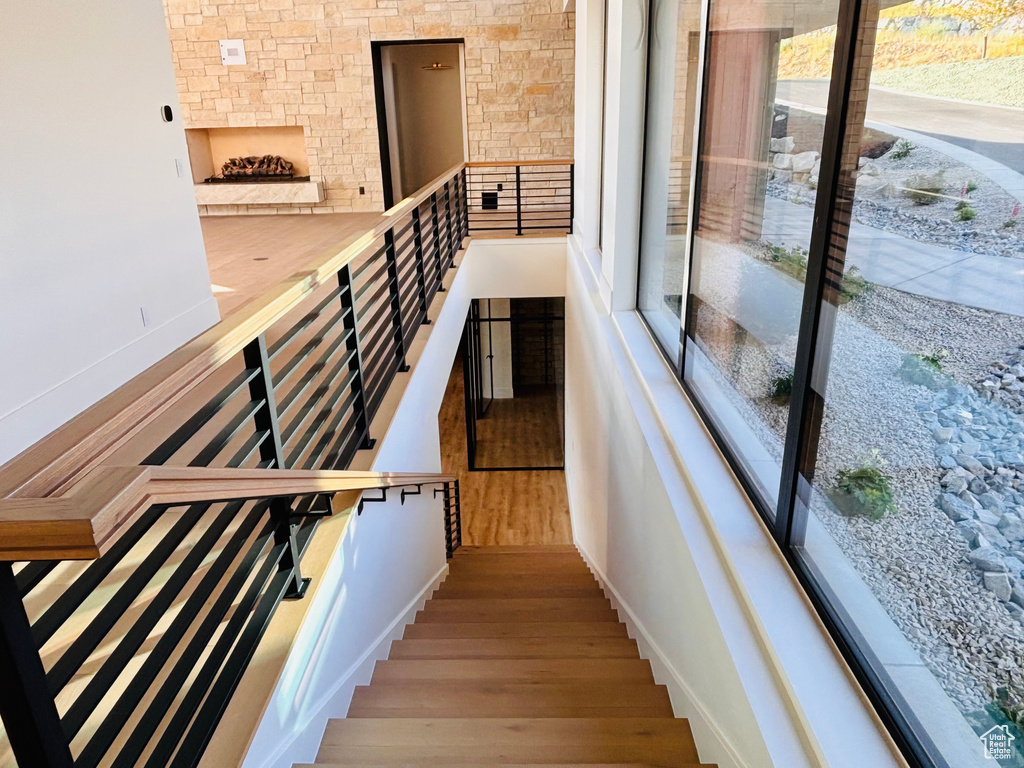 Stairway featuring wood finished floors and an outdoor stone fireplace