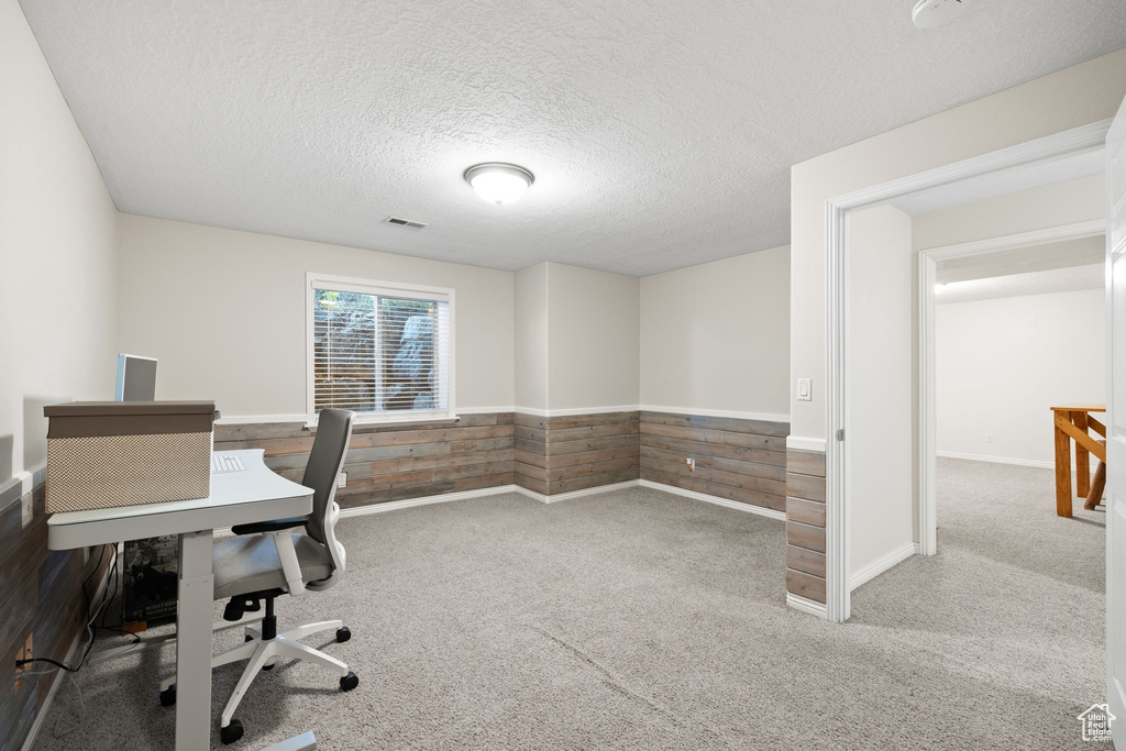 Carpeted office featuring a textured ceiling