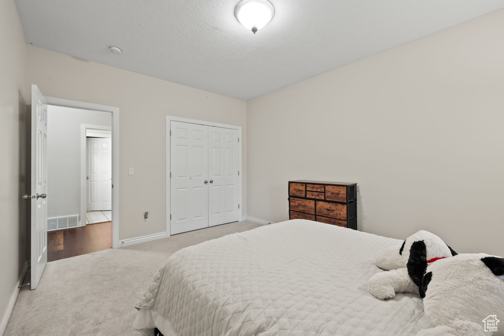 Bedroom with carpet flooring, baseboards, and a closet