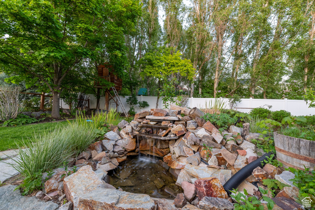 View of patio / terrace with a garden pond and a fenced backyard