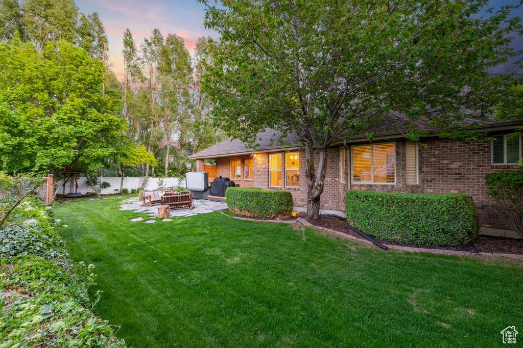 Yard at dusk with outdoor lounge area and a patio area