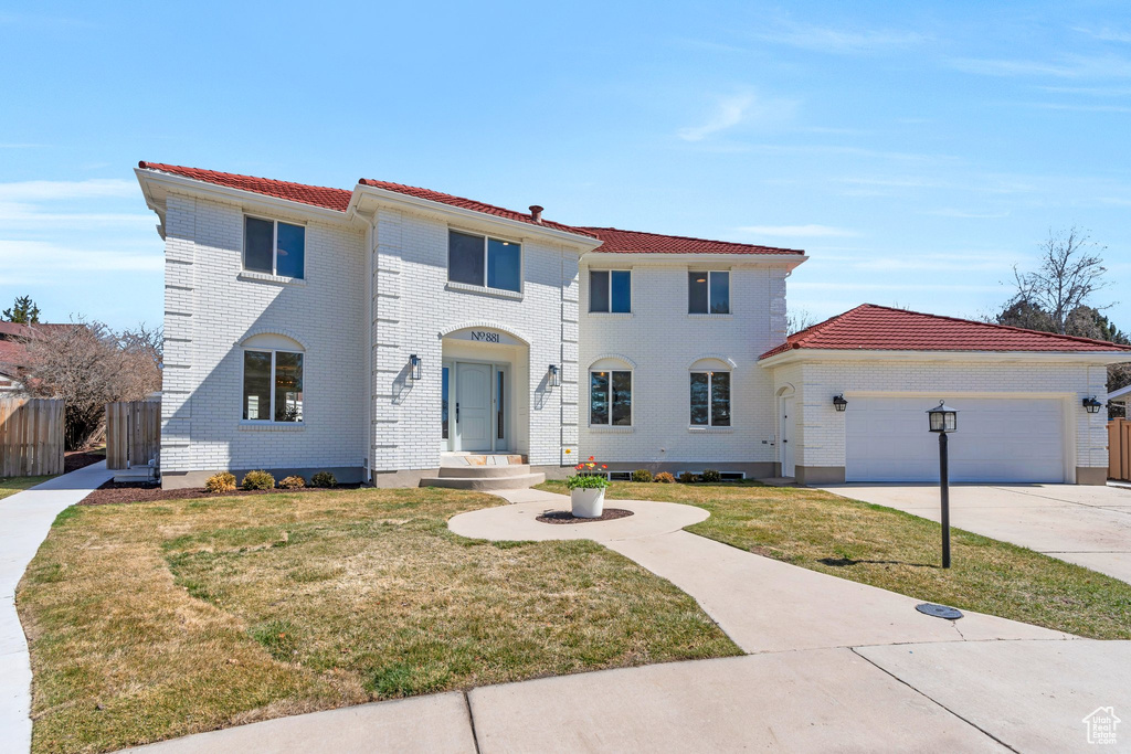 Mediterranean / spanish home with a tiled roof, driveway, a garage, and fence