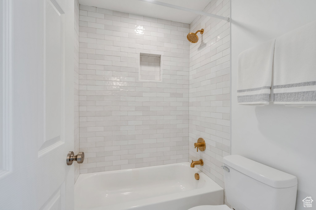 Full bathroom featuring toilet and washtub / shower combination
