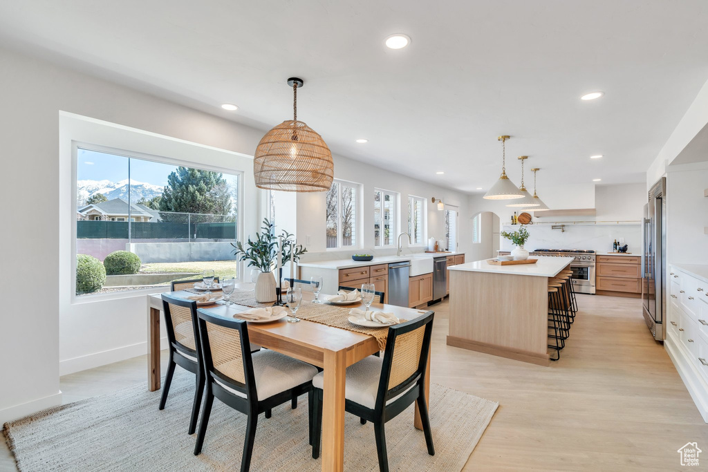 Dining room with baseboards, light wood finished floors, and recessed lighting