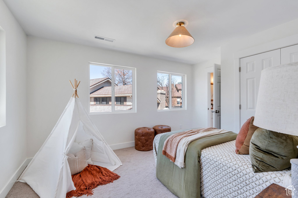Bedroom featuring light carpet, baseboards, and visible vents