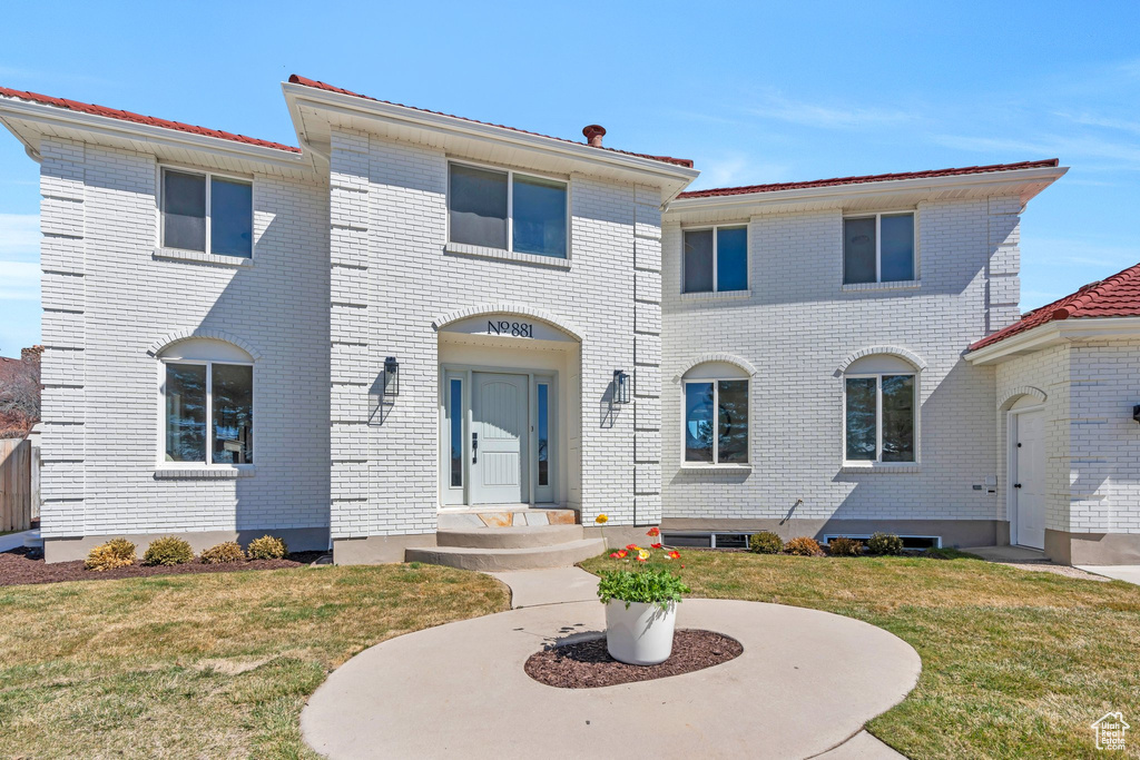 View of front of house with brick siding and a front yard