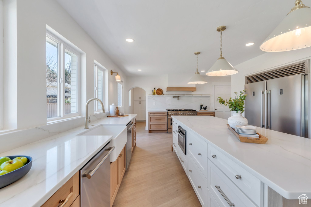 Kitchen featuring stainless steel appliances, recessed lighting, a sink, light wood-style floors, and pendant lighting