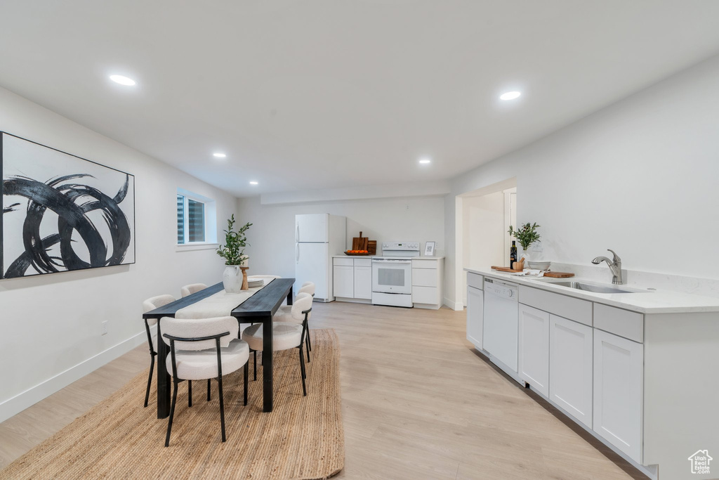 Dining space with light wood finished floors, baseboards, and recessed lighting