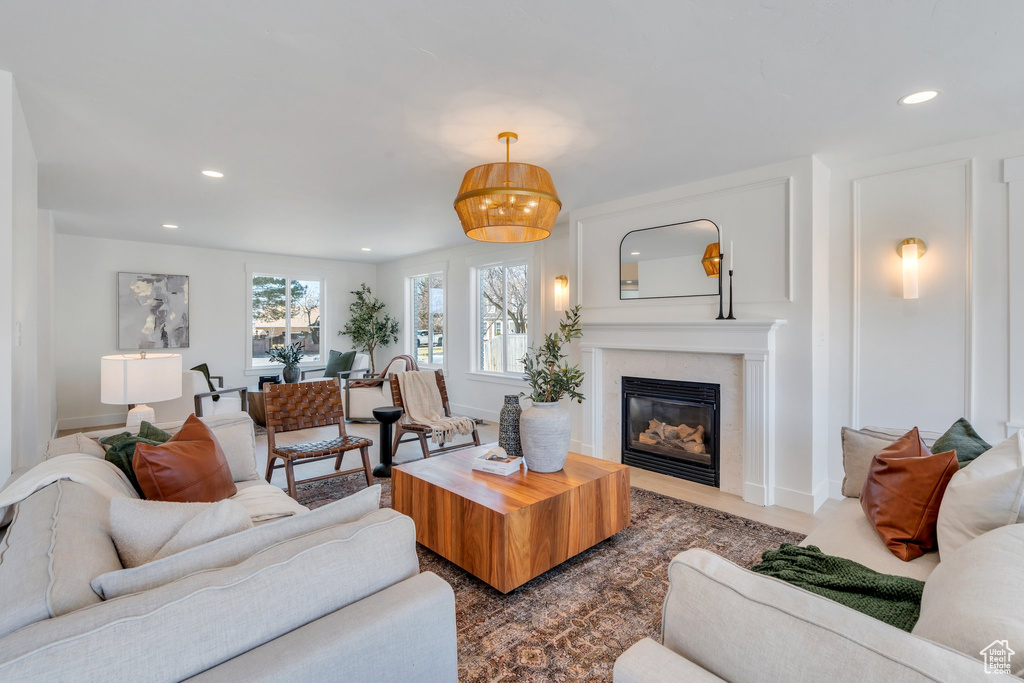 Living room with a glass covered fireplace, baseboards, and recessed lighting