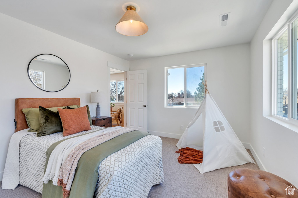Bedroom with baseboards, visible vents, multiple windows, and carpet