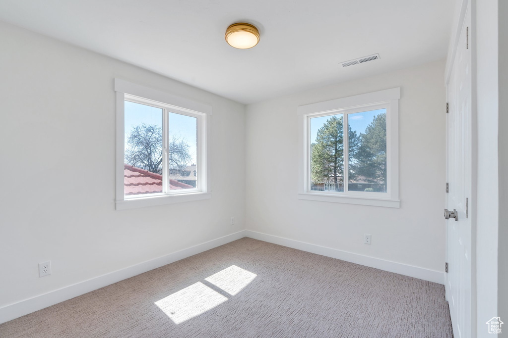 Spare room featuring baseboards, visible vents, and carpet flooring