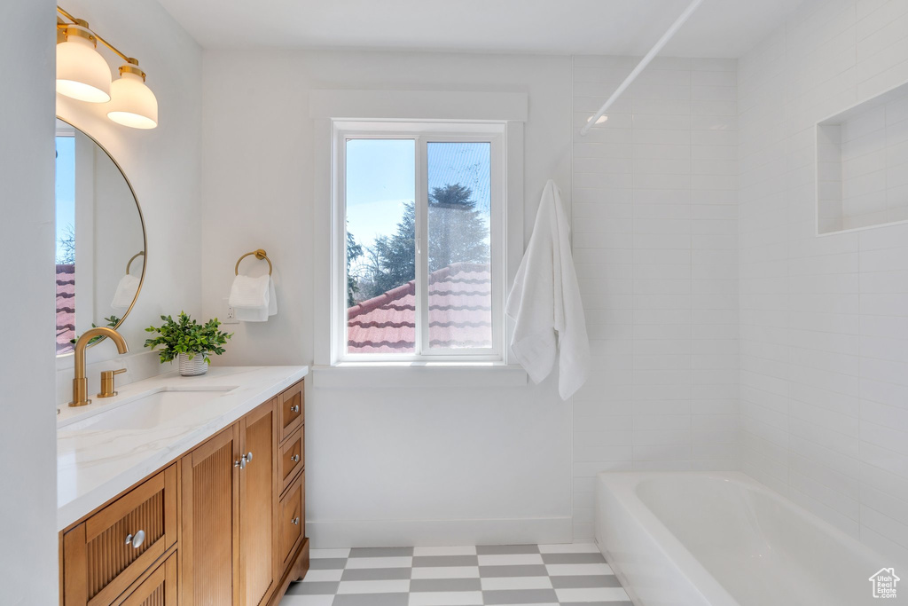 Full bath with tile patterned floors, vanity, and baseboards