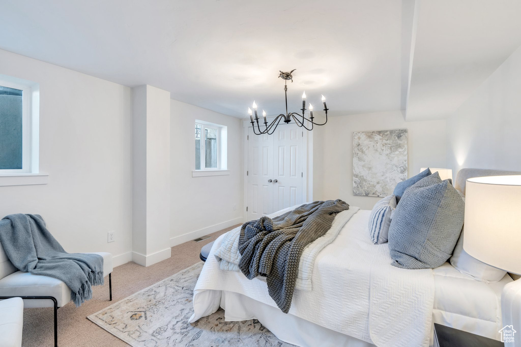 Bedroom featuring baseboards, a chandelier, and carpet