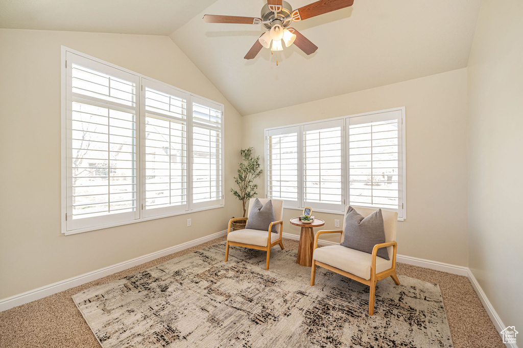 Sitting room featuring baseboards, carpet flooring, vaulted ceiling, and a ceiling fan
