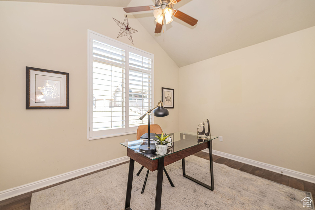 Office space with a ceiling fan, baseboards, lofted ceiling, and wood finished floors