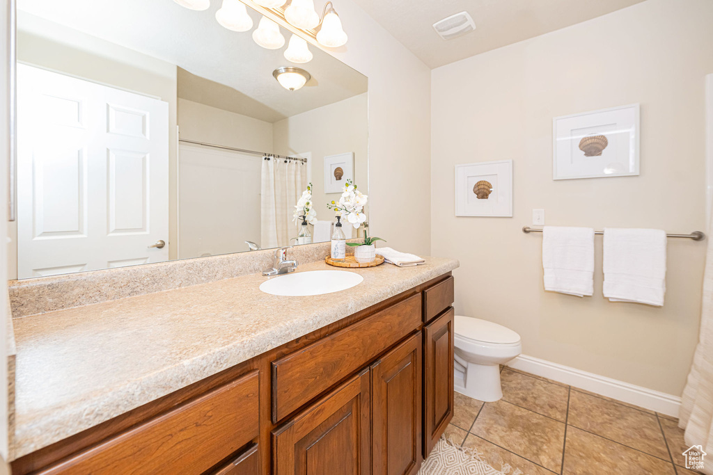 Full bath with visible vents, baseboards, toilet, vanity, and tile patterned flooring