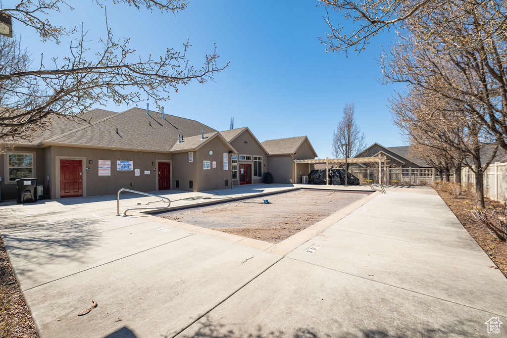 Back of property with a patio area, stucco siding, fence, and roof with shingles