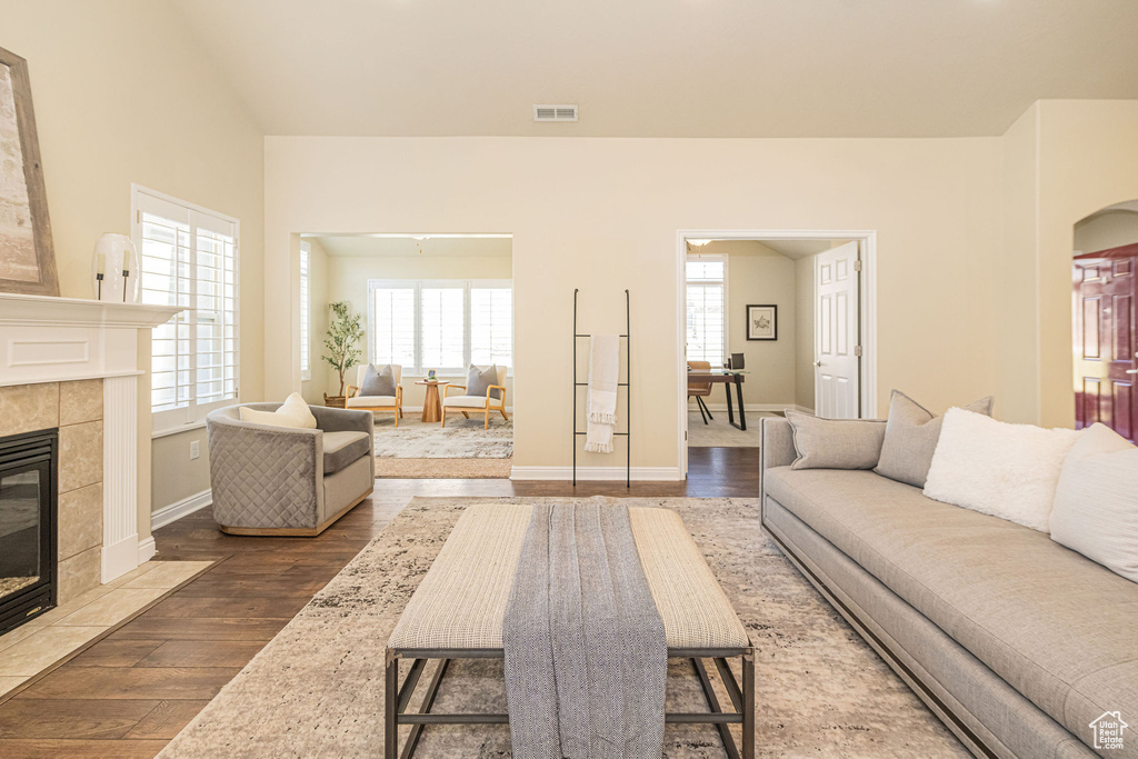 Living room featuring baseboards, visible vents, wood finished floors, and a fireplace