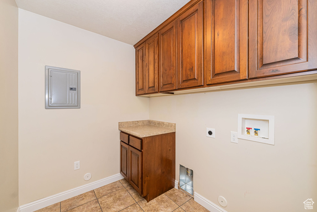 Laundry area with hookup for a gas dryer, light tile patterned floors, hookup for a washing machine, electric dryer hookup, and electric panel