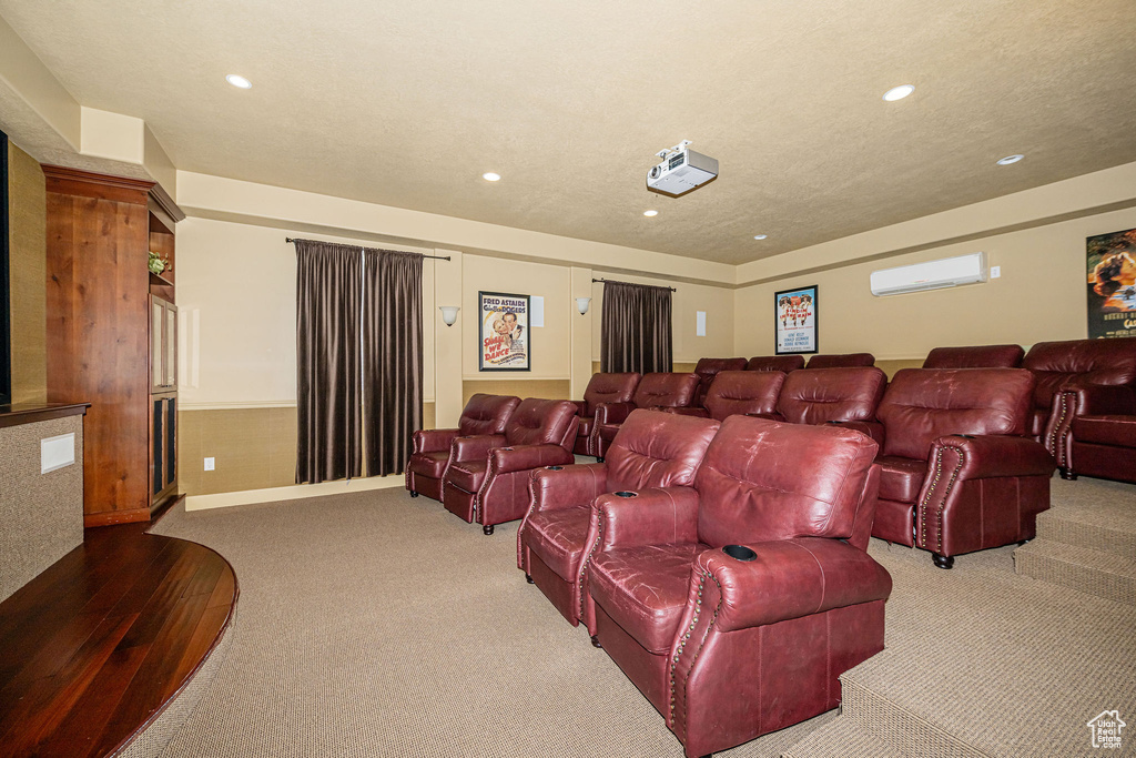 Home theater with a textured ceiling, a wall unit AC, and recessed lighting
