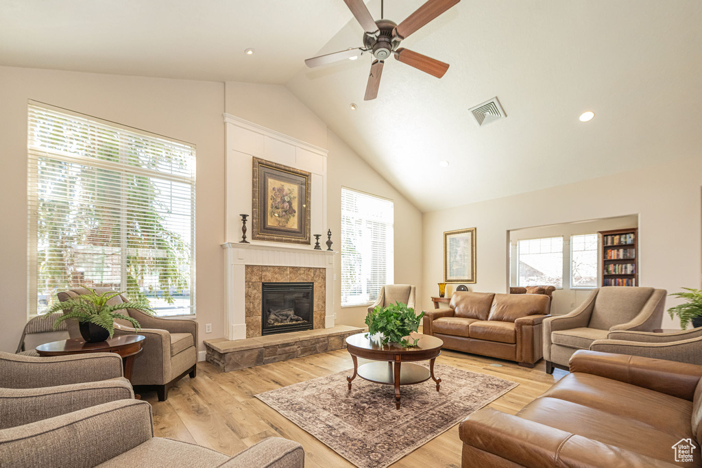 Living room featuring light wood-style flooring, visible vents, a healthy amount of sunlight, and a ceiling fan