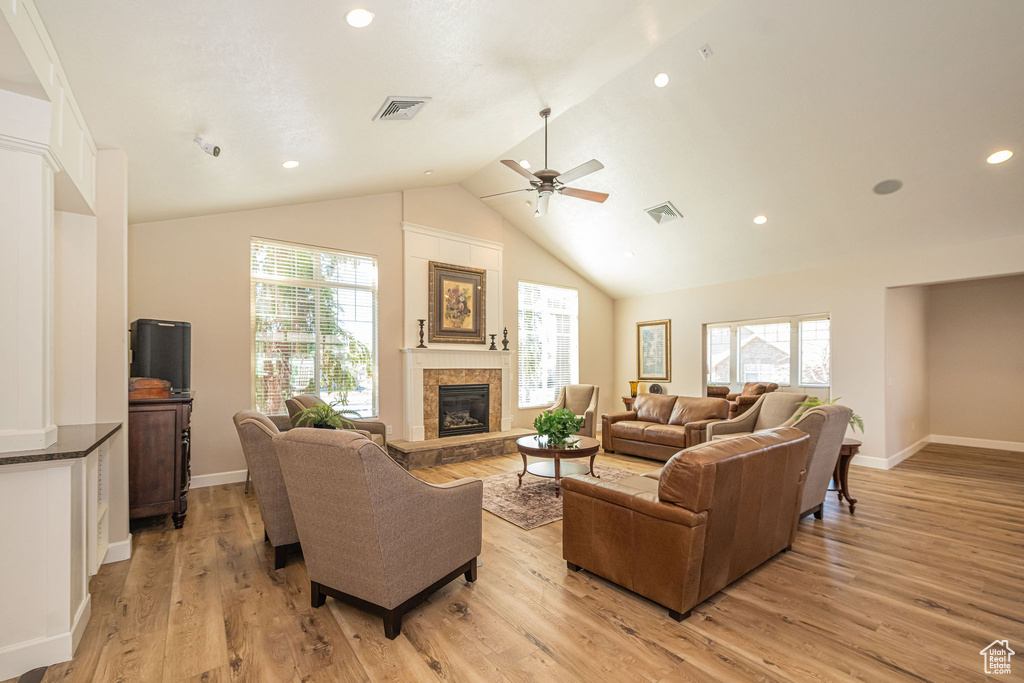 Living area featuring light wood-style flooring, a fireplace, and visible vents