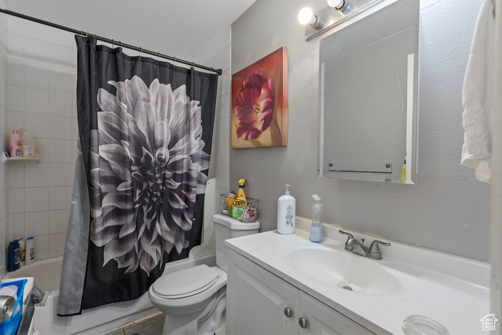 Bathroom featuring toilet, vanity, and shower / tub combo