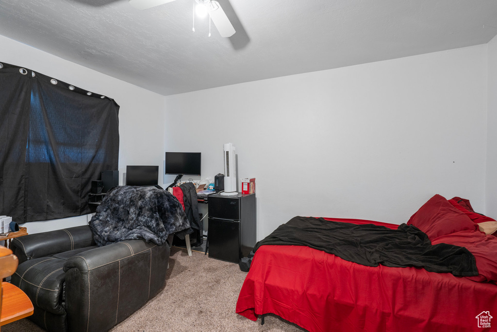 Carpeted bedroom featuring ceiling fan