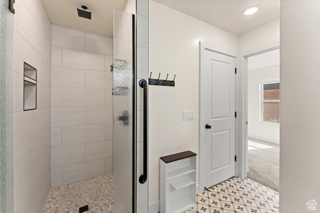 Bathroom featuring tile patterned floors and a shower stall